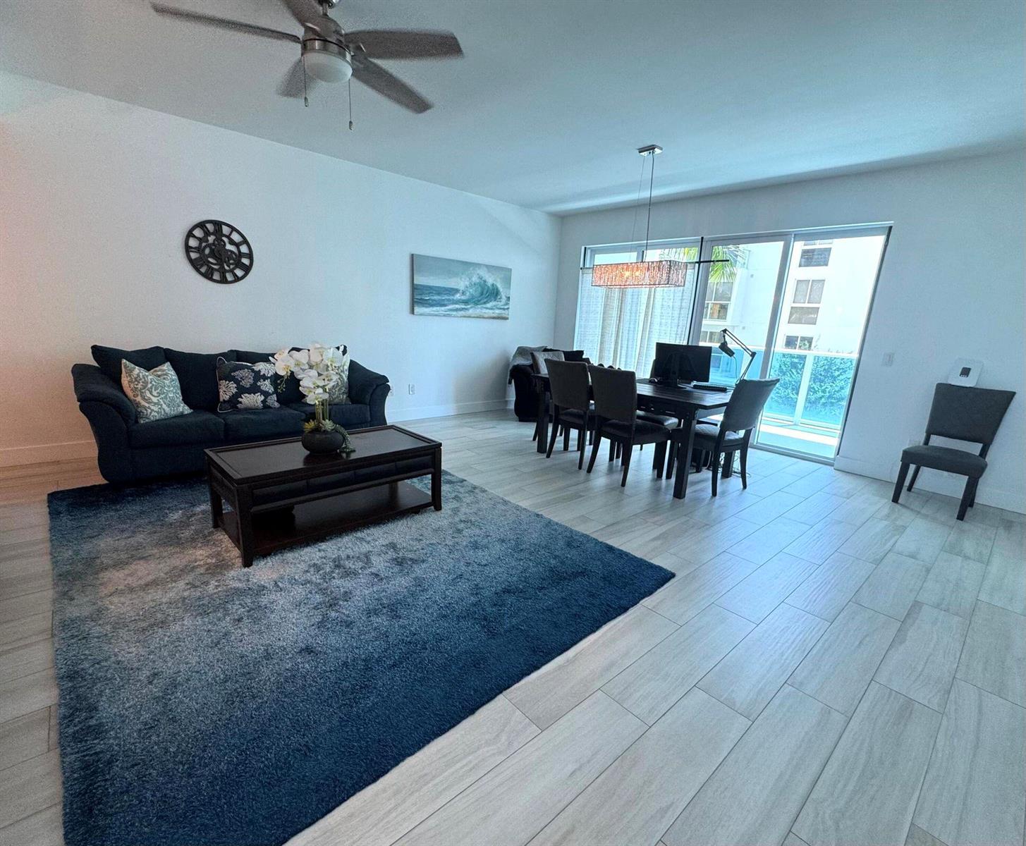 A living and dining area features a dark sofa, a blue rug, and tile flooring — 1 S Palmway # 204, FL 33460, FL