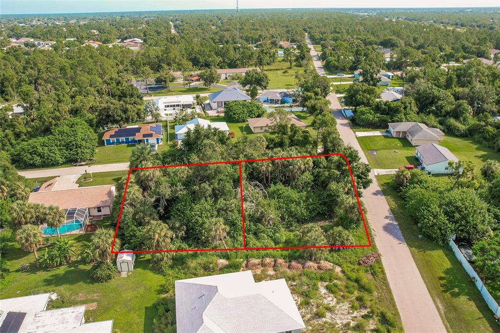 An aerial view shows two adjacent, heavily wooded vacant lots outlined in red — 23193 RYE AVENUE, PUNTA GORDA, FL