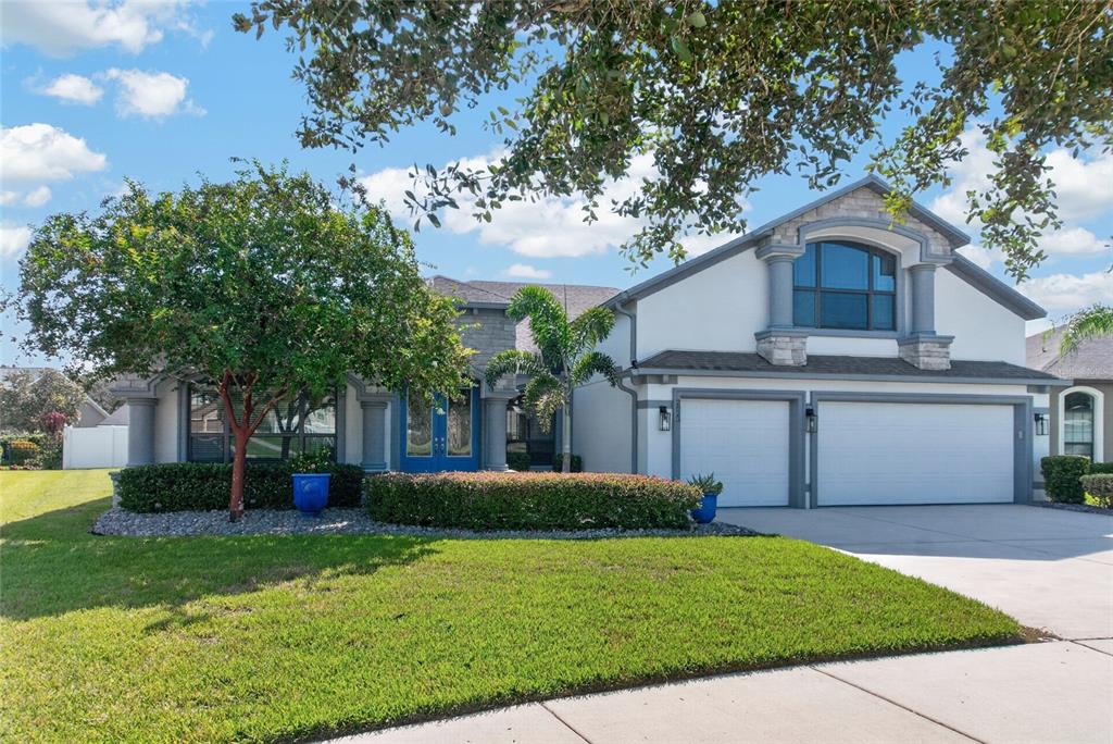 A two-story house with a white stucco exterior, a two-car garage, and blue double doors — 2823 COLEWOOD LANE, DOVER, FL