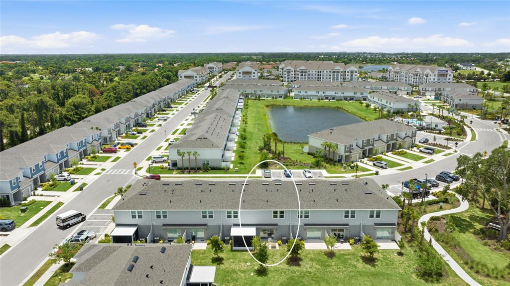 An aerial view shows a row of townhomes with a circled unit and a pond — 15067 GINETTI STREET, NOKOMIS, FL