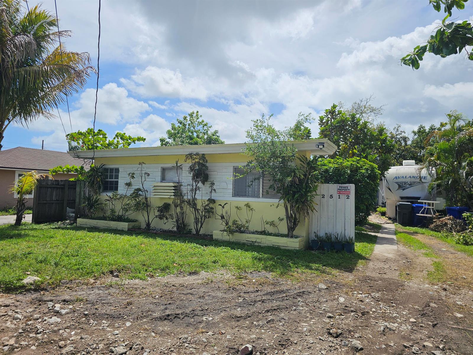 A single-story yellow house with a flat roof, white trim, and a gravel driveway — 2512 Arthur Street, Hollywood FL 33020, HOLLYWOOD, FL