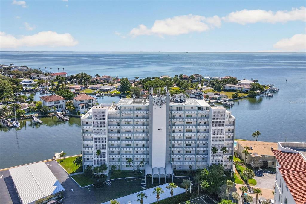 An aerial view shows a multi-story apartment building situated on a waterfront property — 1365 SNELL ISLE BOULEVARD NE UNIT 6A, ST PETERSBURG, FL