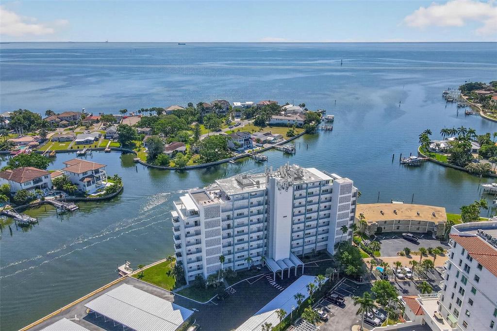 An aerial view shows a multi-story apartment building surrounded by waterfront homes and a bay — 1365 SNELL ISLE BOULEVARD NE UNIT 6A, ST PETERSBURG, FL