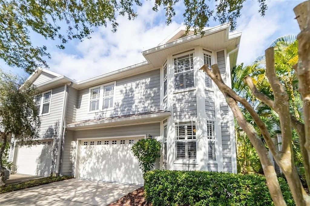 A two-story house with light gray siding, a two-car garage, and a bay window — 2889 BAYSHORE TRAILS DRIVE, TAMPA, FL