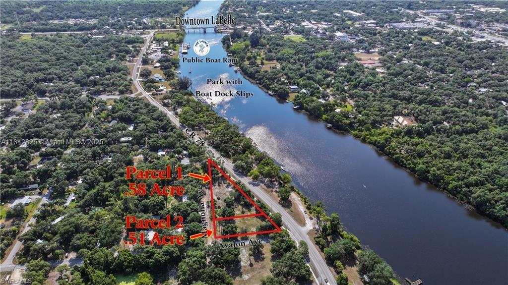 This aerial view shows two adjacent land parcels located next to a river and road — 0 Magnolia Ave, La Belle FL 33935, LA BELLE, FL