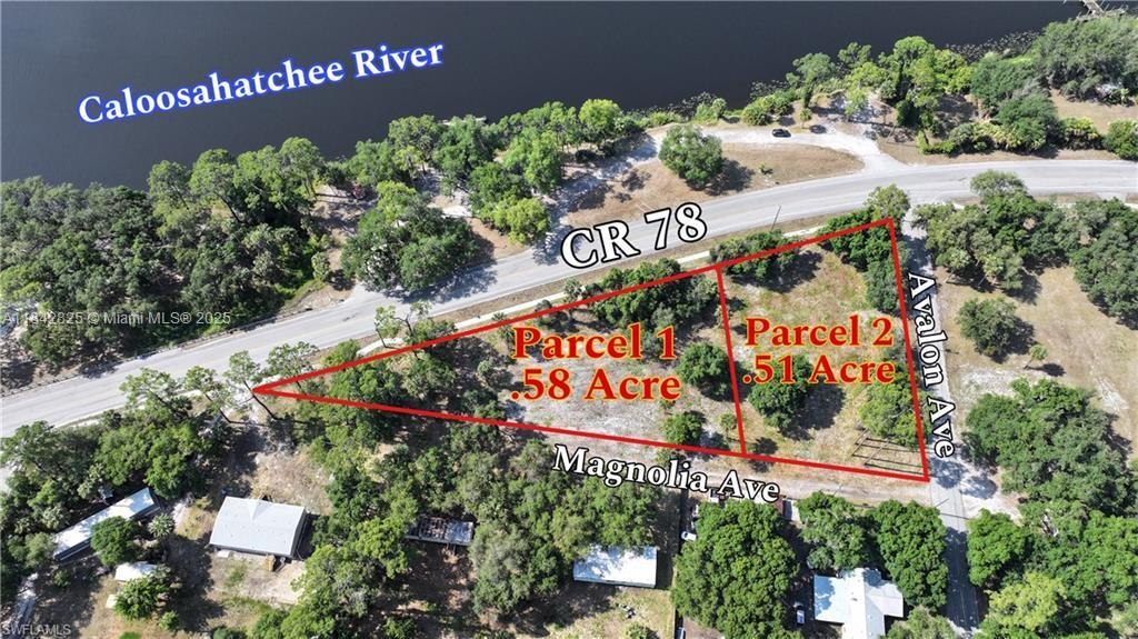 This aerial view shows two adjacent land parcels outlined in red near a river — 0 Magnolia Ave, La Belle FL 33935, LA BELLE, FL