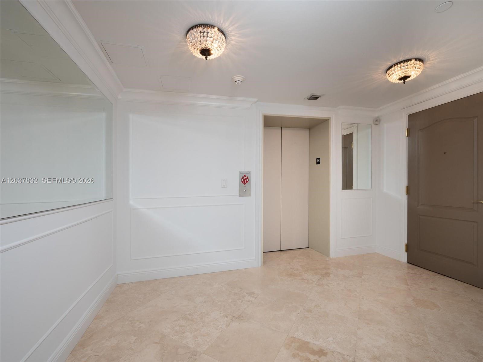 A bright elevator lobby features white paneled walls, crystal flush-mount lights, and tiled flooring — 200 E Palmetto Park Rd # 700, Boca Raton FL 33432, BOCA RATON, FL
