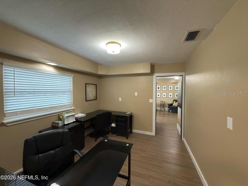 An office room features a dark desk, wood-look flooring, and a window with blinds — 160 SW NIGHTINGALE STREET, KEYSTONE HEIGHTS, FL