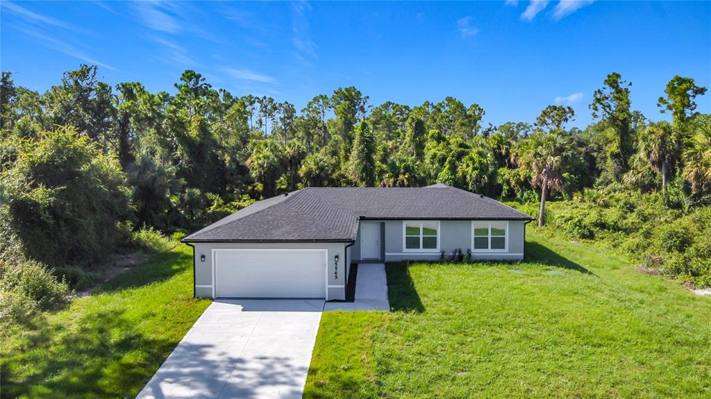 A single-story house with a white garage and gray exterior sits on a grassy lot — 3067 QUARTER STREET, NORTH PORT, FL