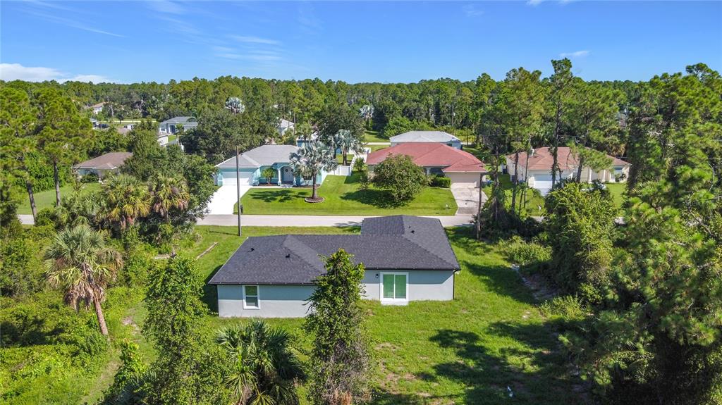 An aerial view shows a single-story house with a dark roof surrounded by trees — 3067 QUARTER STREET, NORTH PORT, FL