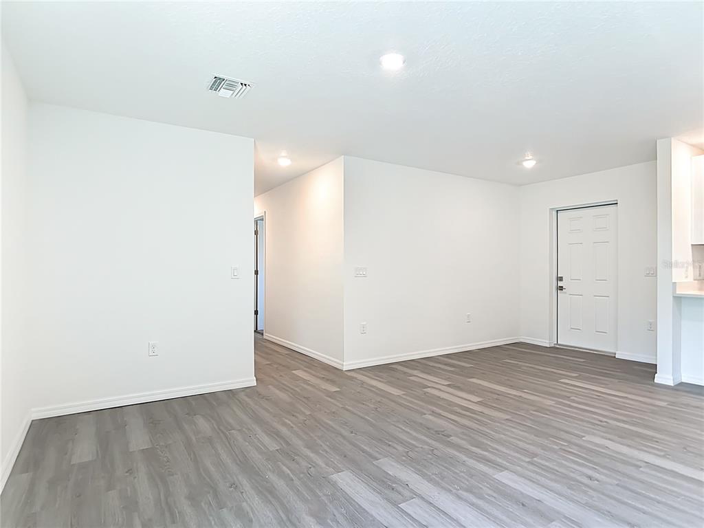 An interior view of a room with white walls, recessed lighting, and gray wood flooring — 3067 QUARTER STREET, NORTH PORT, FL