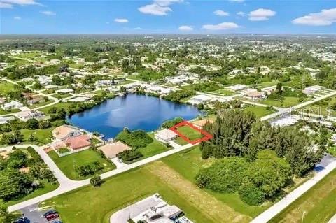An aerial view shows a vacant residential lot outlined in red near a small lake — SARAGOSSA LANE, NORTH PORT, FL