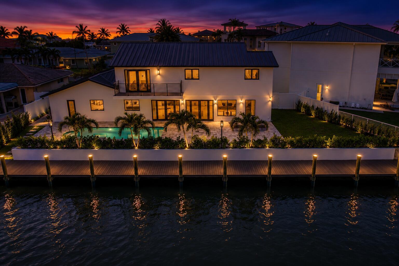 An aerial view of a two-story house with a pool, dock, and sunset sky — 3711 NE 27th Avenue, Lighthouse Point FL 33064, LIGHTHOUSE POINT, FL