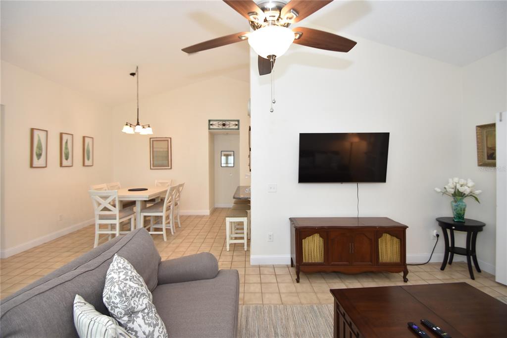 A living room and dining area with tile floors, a ceiling fan, and a television — 34 ANDOVER DRIVE, PALM COAST, FL