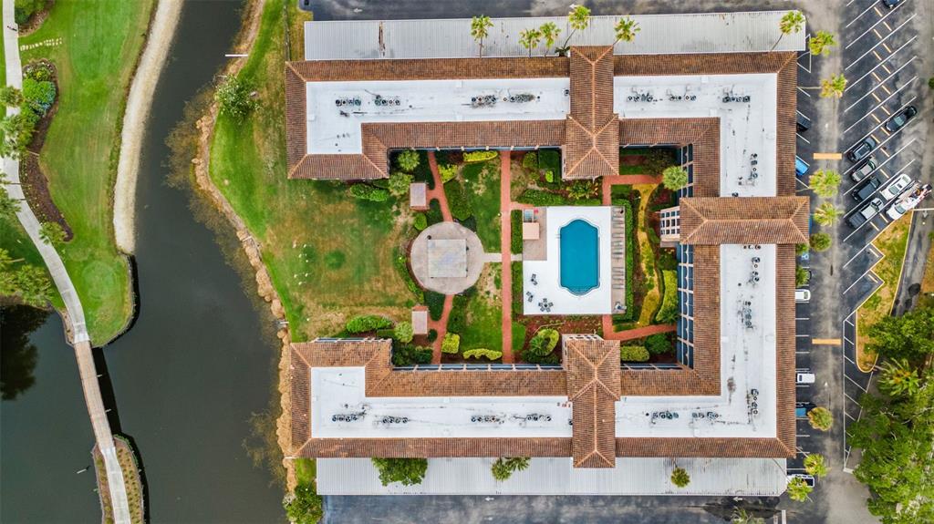 An aerial view shows a U-shaped building surrounding a courtyard with a pool and gazebo — 6100 GULFPORT BOULEVARD S UNIT 402, GULFPORT, FL