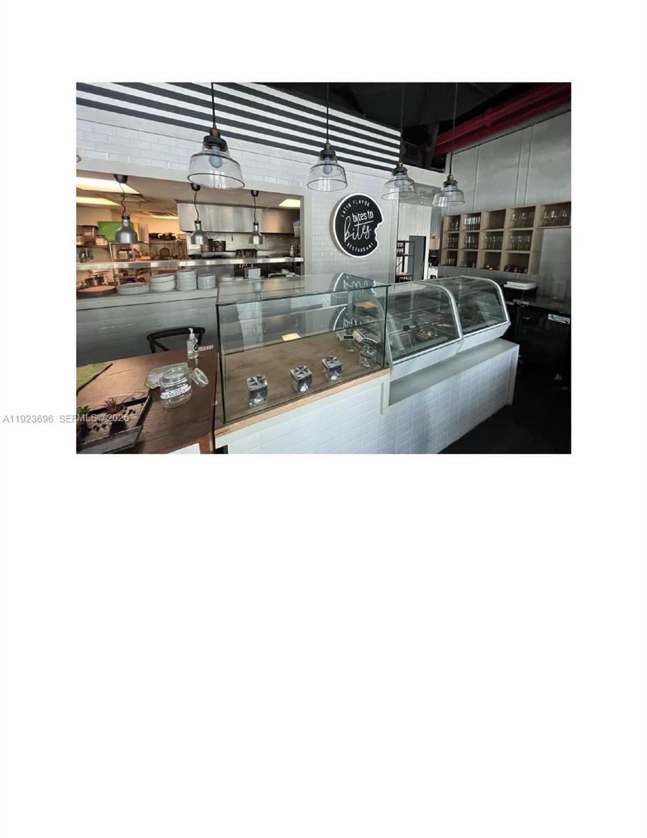 A restaurant interior features a service counter with glass display cases and pendant lighting — Downtown Miami, Miami FL 33132, MIAMI, FL