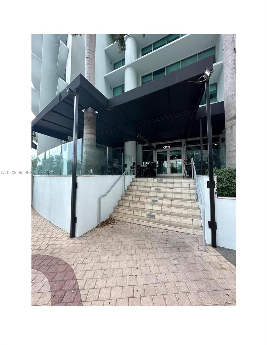 The exterior of a building features a black awning over a set of stone stairs — Downtown Miami, Miami FL 33132, MIAMI, FL