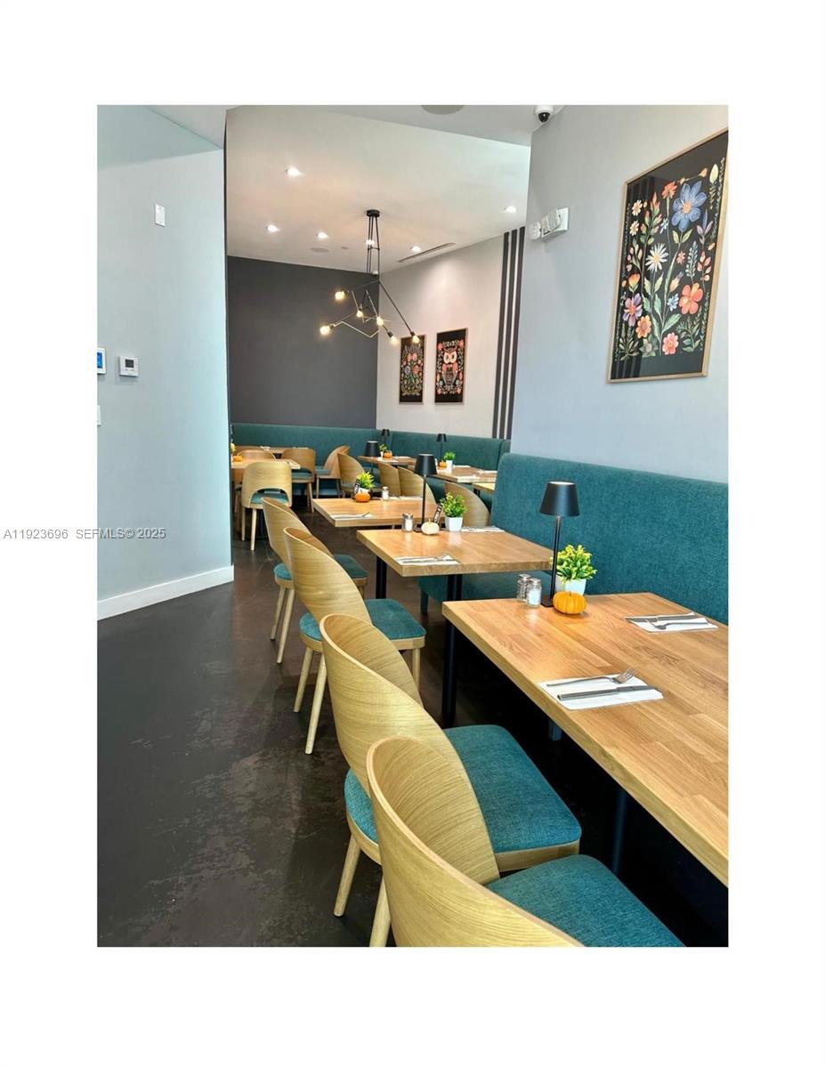 A restaurant dining area features wooden tables, teal upholstered chairs, and a long bench seat — Downtown Miami, Miami FL 33132, MIAMI, FL