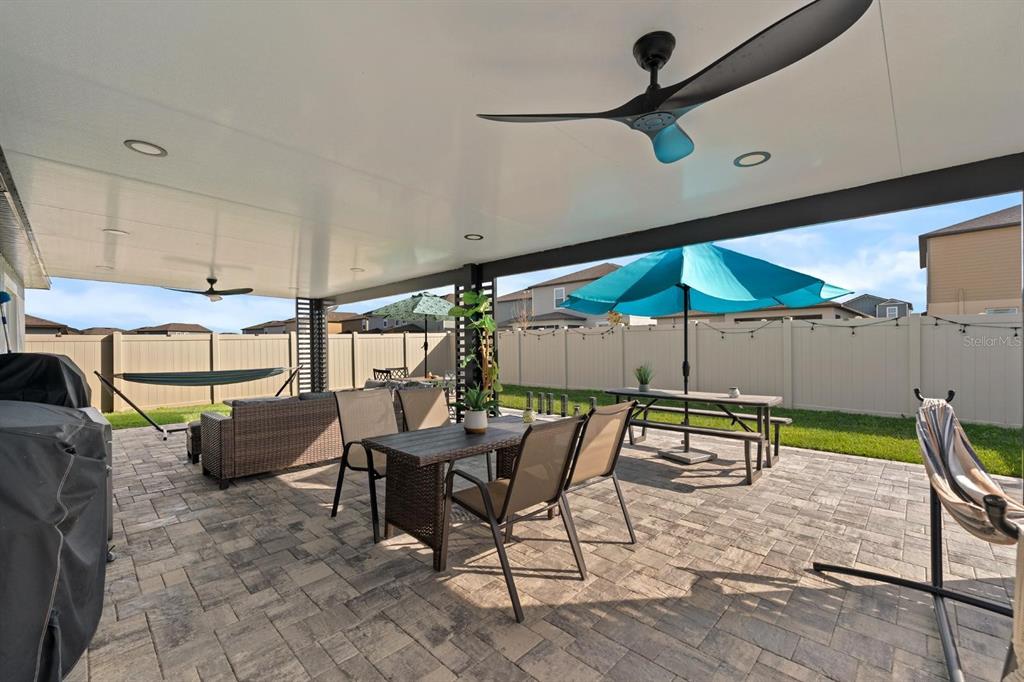 A covered patio features a paved floor, outdoor furniture, a ceiling fan, and a fenced yard — 32024 HAWTHORNE COTTAGE PLACE, SAN ANTONIO, FL
