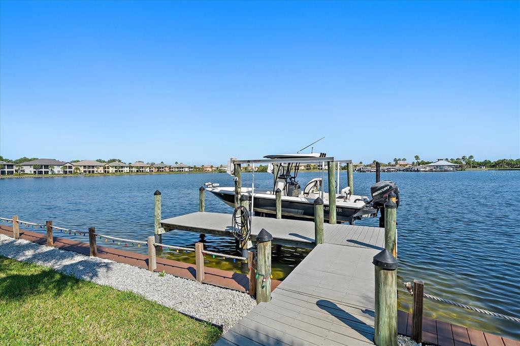 A boat is docked at a wooden pier extending into a calm lake — 5040 LAKE OVERLOOK AVENUE, BRADENTON, FL
