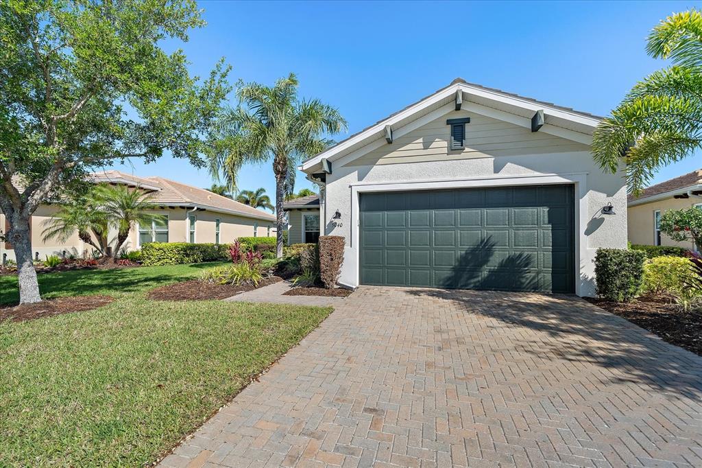 A single-story house with a dark green garage door and a paved driveway — 5040 LAKE OVERLOOK AVENUE, BRADENTON, FL