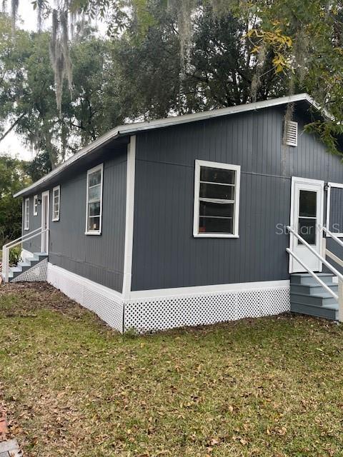 A dark gray exterior of a single-story home with white trim and lattice skirting — 25317 NW 6TH AVENUE, NEWBERRY, FL