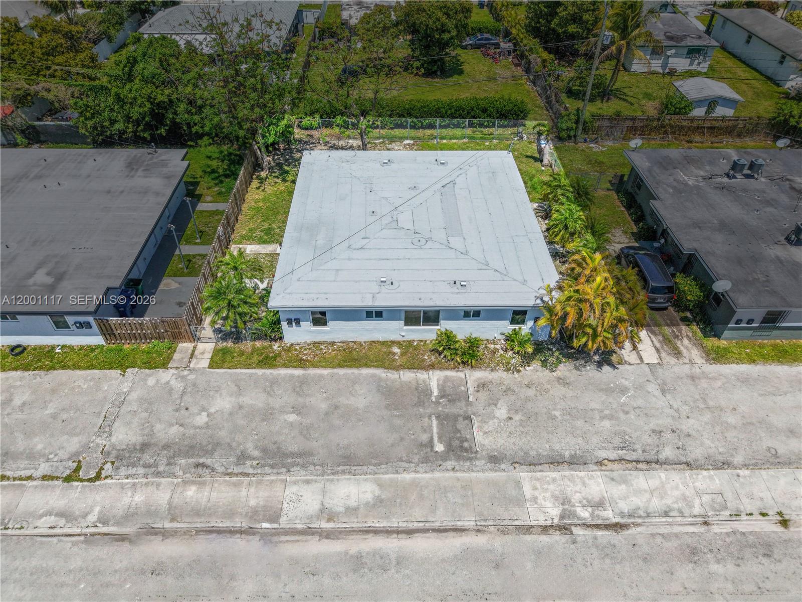 An aerial view shows a light-colored building with a flat roof and surrounding palm trees — 11775 SW 223rd St, Miami FL 33170, MIAMI, FL