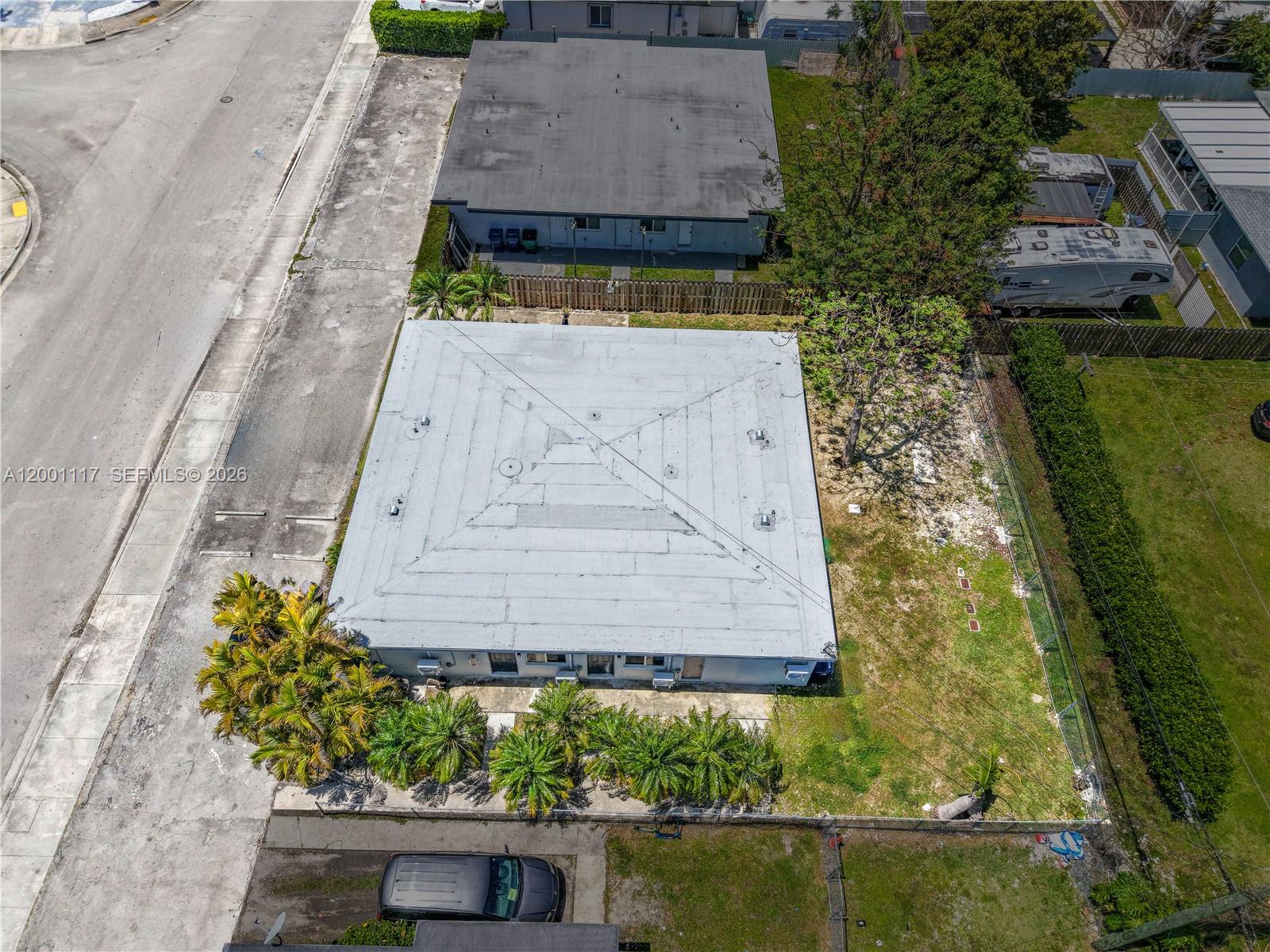An aerial view shows a flat-roofed building with a large yard and surrounding vegetation — 11775 SW 223rd St, Miami FL 33170, MIAMI, FL
