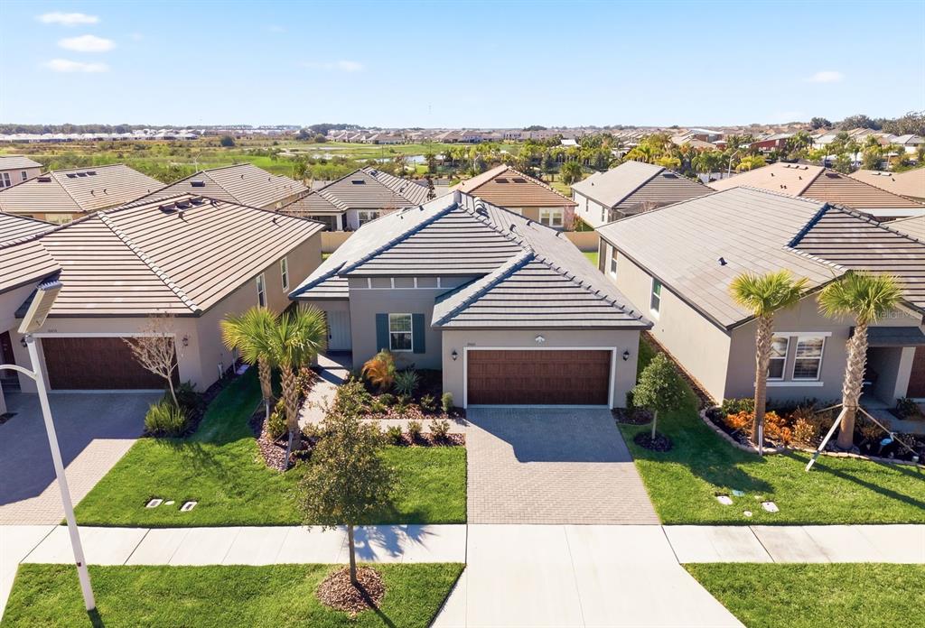 An aerial view shows a suburban house with a tiled roof and a paved driveway — 10661 TUPPER CAY DRIVE, SAN ANTONIO, FL