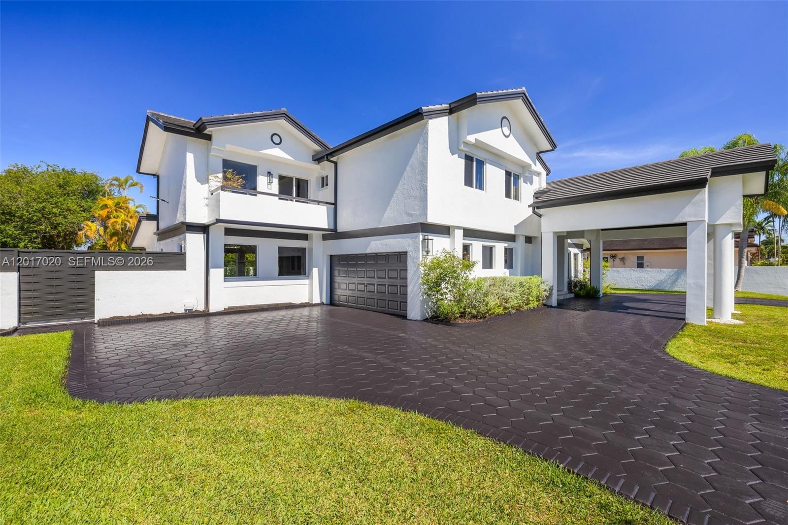 A two-story white house features a dark-tiled driveway, a garage, and a covered entryway — 3352 SW 110th Ave, Miami FL 33165, MIAMI, FL