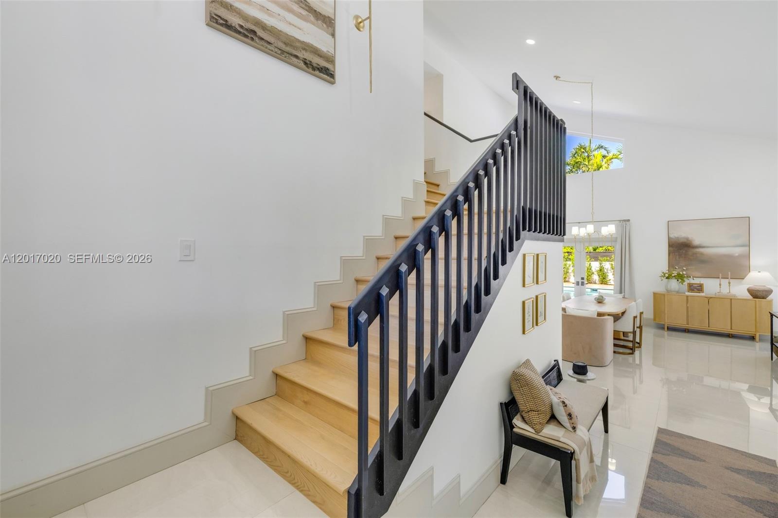 A staircase with light wood treads and a dark blue railing leads to an upper level — 3352 SW 110th Ave, Miami FL 33165, MIAMI, FL