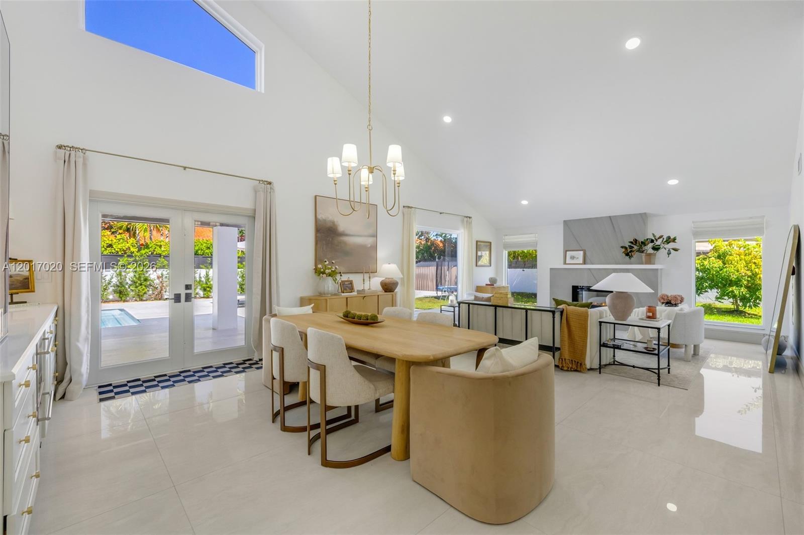 A bright, open-concept living and dining area features vaulted ceilings, tile floors, and a fireplace — 3352 SW 110th Ave, Miami FL 33165, MIAMI, FL