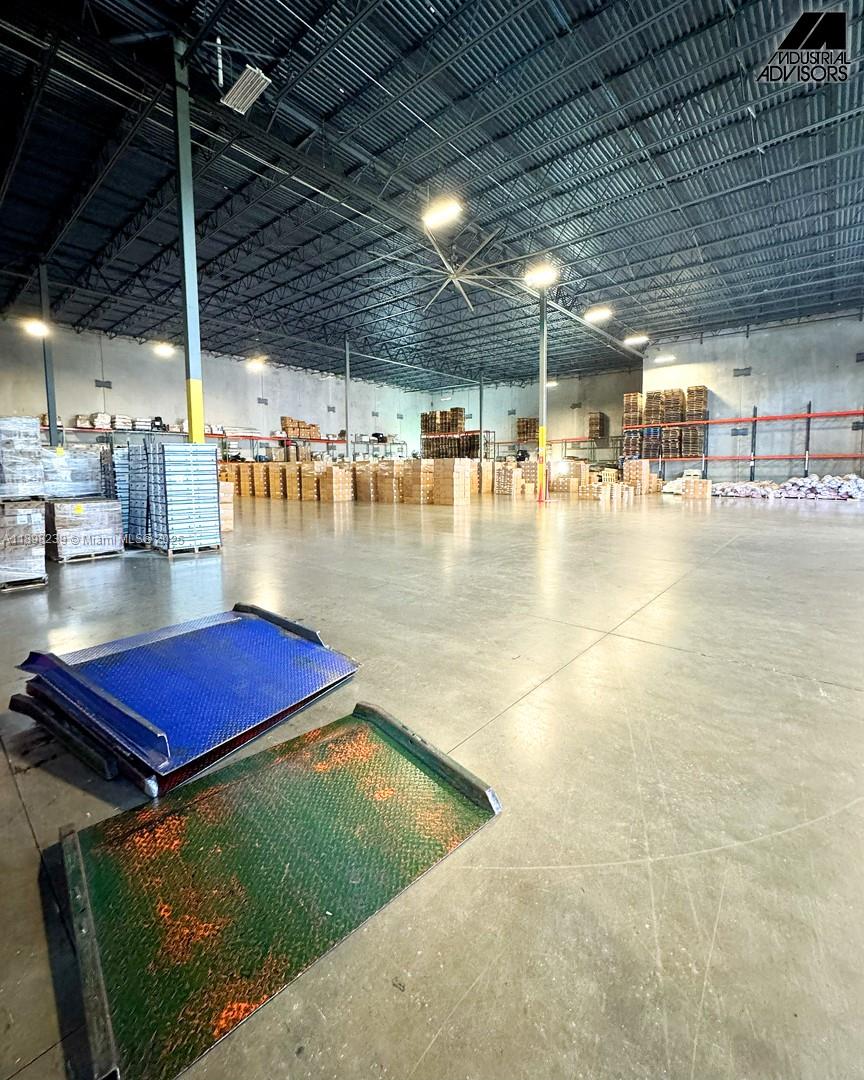 A large warehouse interior features high ceilings, concrete floors, and stacked inventory on pallets — 6725 NW 36th St, Miami FL 33166, MIAMI, FL