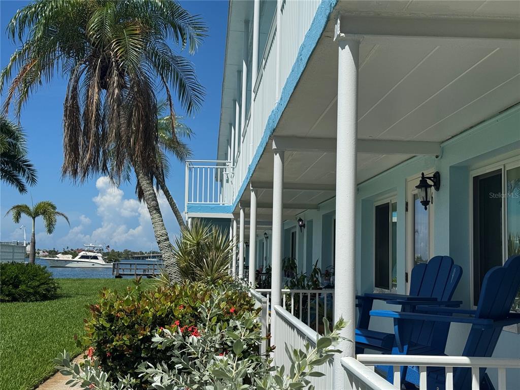 A blue building with a covered porch, blue chairs, and a view of the water — 1834 SHORE DRIVE S UNIT 6, SOUTH PASADENA, FL