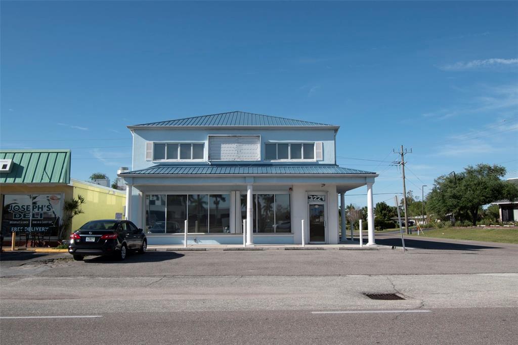 A light blue two-story commercial building with a metal roof and large front windows — 3221 TAMIAMI TRL UNIT 16, PORT CHARLOTTE, FL