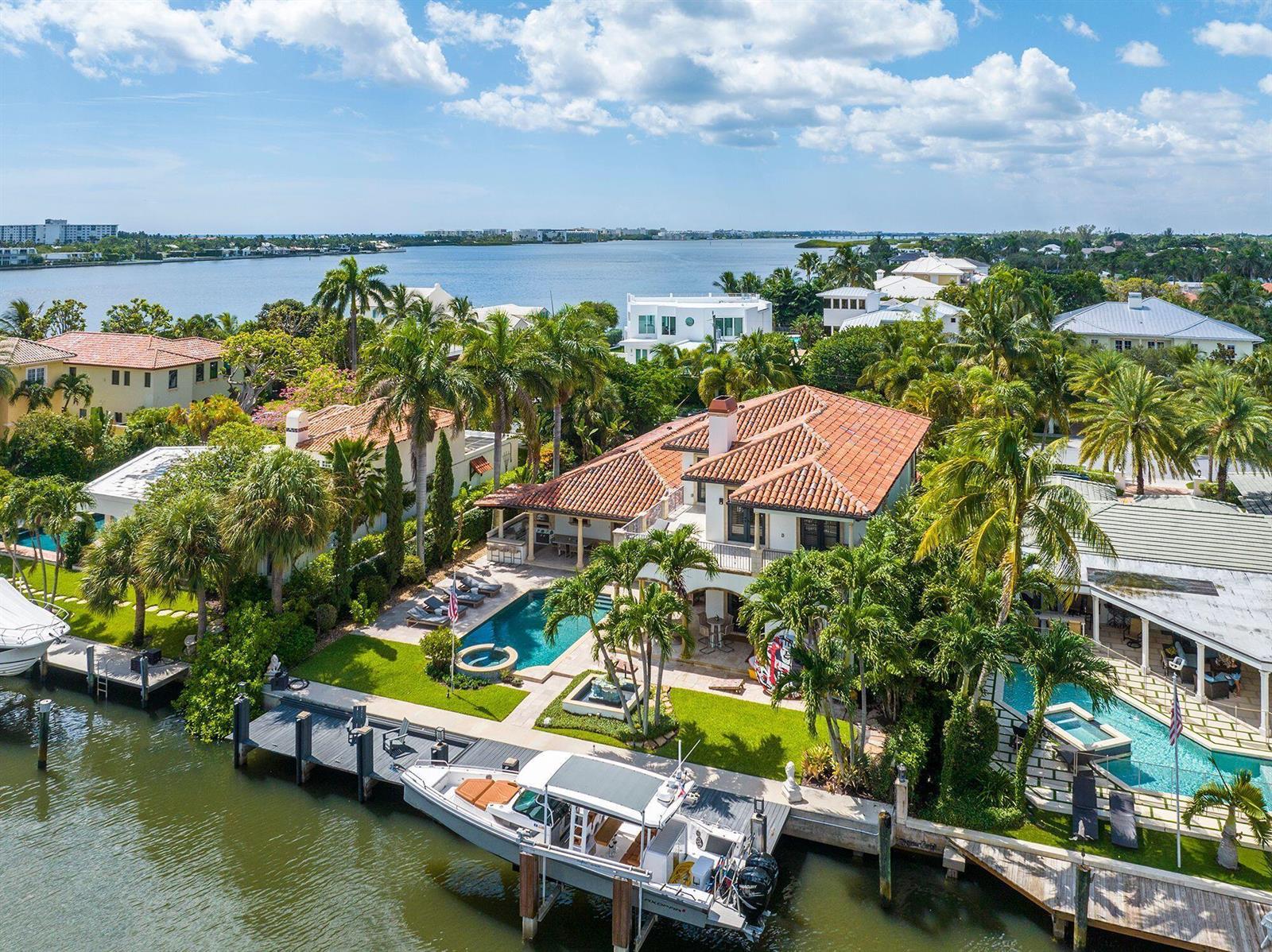 An aerial view of a waterfront home with a pool, dock, and boat in Florida — 14 Harbor Drive, FL 33460, FL