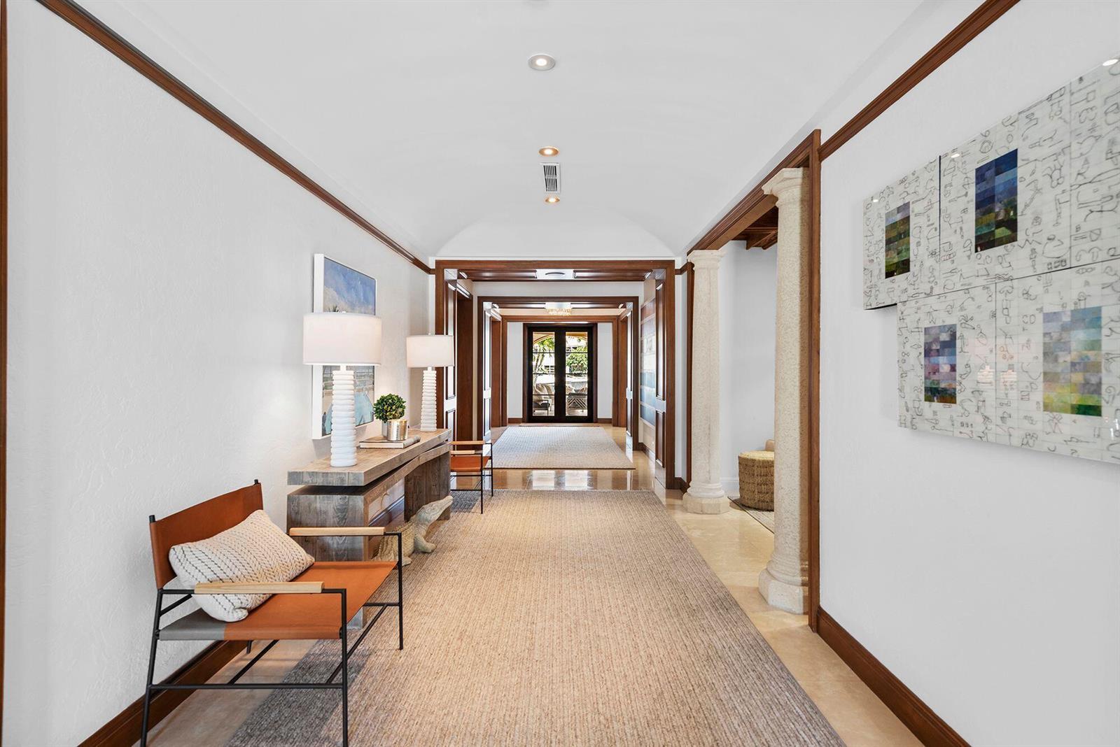 A long hallway features stone columns, wood trim, a console table, and a leather chair — 14 Harbor Drive, FL 33460, FL