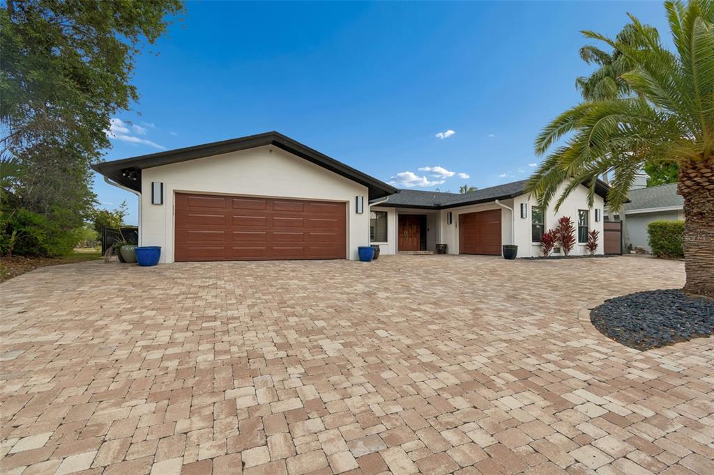 A single-story house with a large paver driveway, two garage doors, and a palm tree — 4213 SALTWATER BOULEVARD, TAMPA, FL