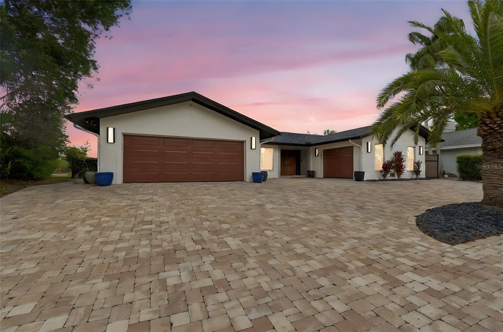 A single-story house with a large paver driveway, two garage doors, and a palm tree — 4213 SALTWATER BOULEVARD, TAMPA, FL