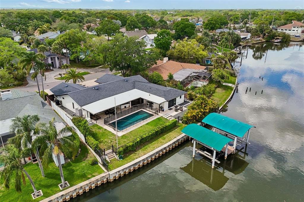 An aerial view shows a waterfront house with a swimming pool and two boat lifts — 4213 SALTWATER BOULEVARD, TAMPA, FL