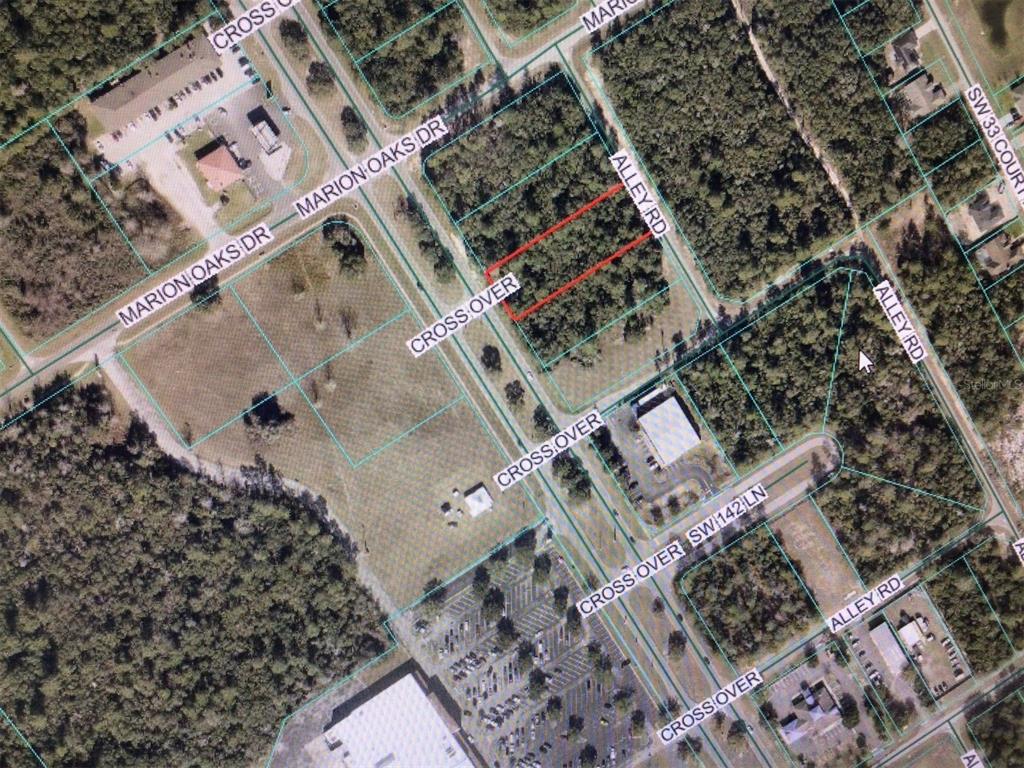 This is an aerial map showing a wooded lot outlined in red near paved roads — 0 MARION OAKS BOULEVARD, OCALA, FL
