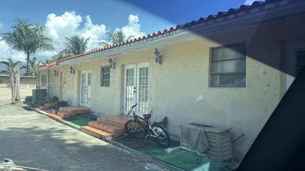 The exterior of a single-story stucco building features tiled steps leading to multiple glass-paned doors — 4000 SW 126th Ave, Miramar FL 33027, MIRAMAR, FL