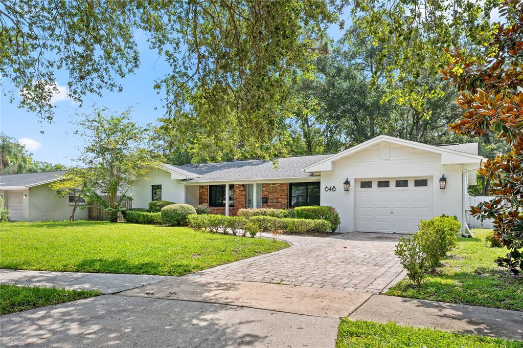 A single-story house with a white exterior, brick accents, and a paved driveway — 648 FITZWALTER DRIVE, WINTER PARK, FL