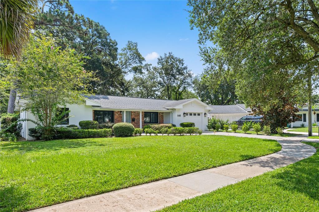 A white single-story house with a brick accent, a garage, and a large front lawn — 648 FITZWALTER DRIVE, WINTER PARK, FL