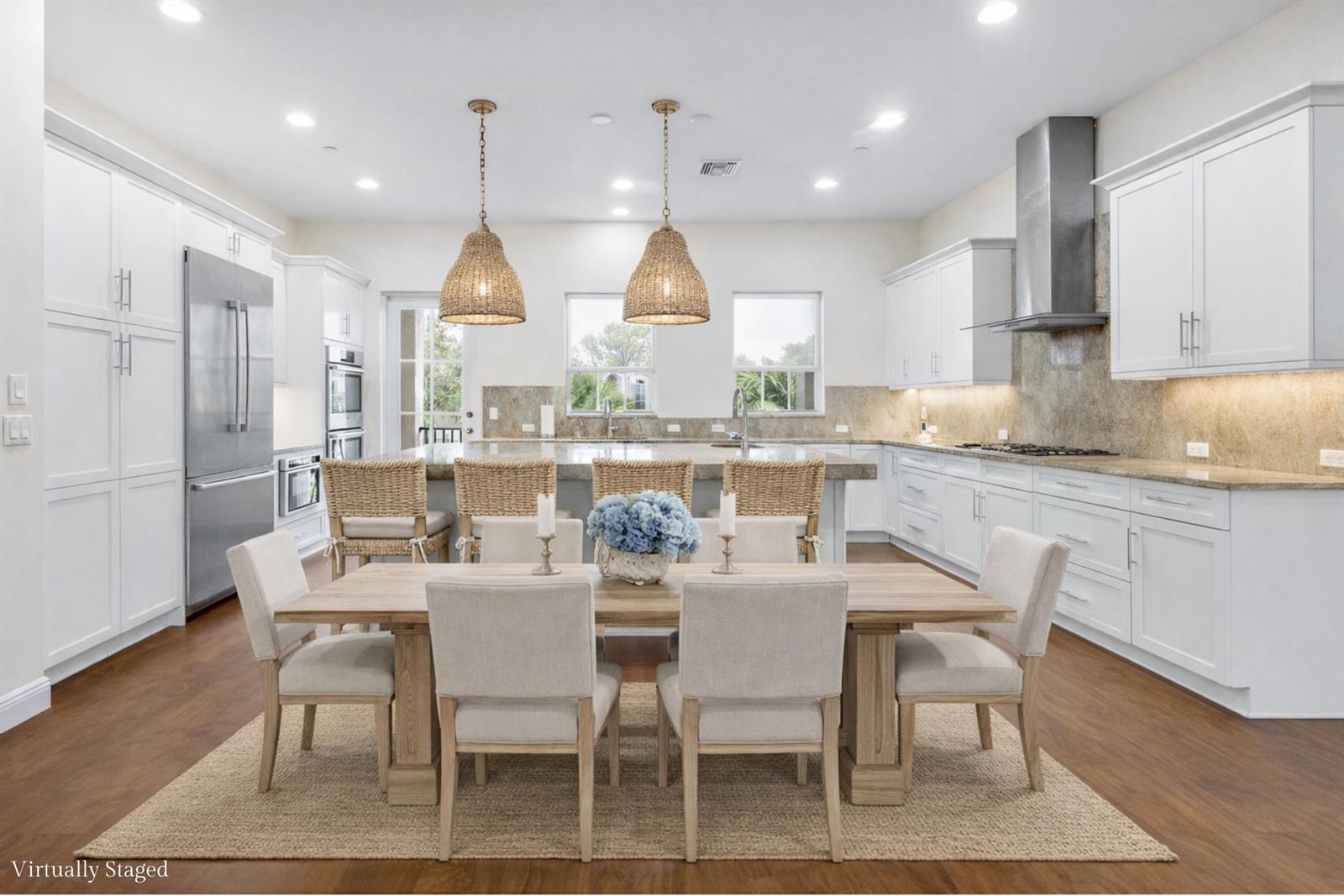 A kitchen and dining area with white cabinetry, a large island, and a wooden table — 144 Tierra Lane # 11, Jupiter FL 33477, JUPITER, FL