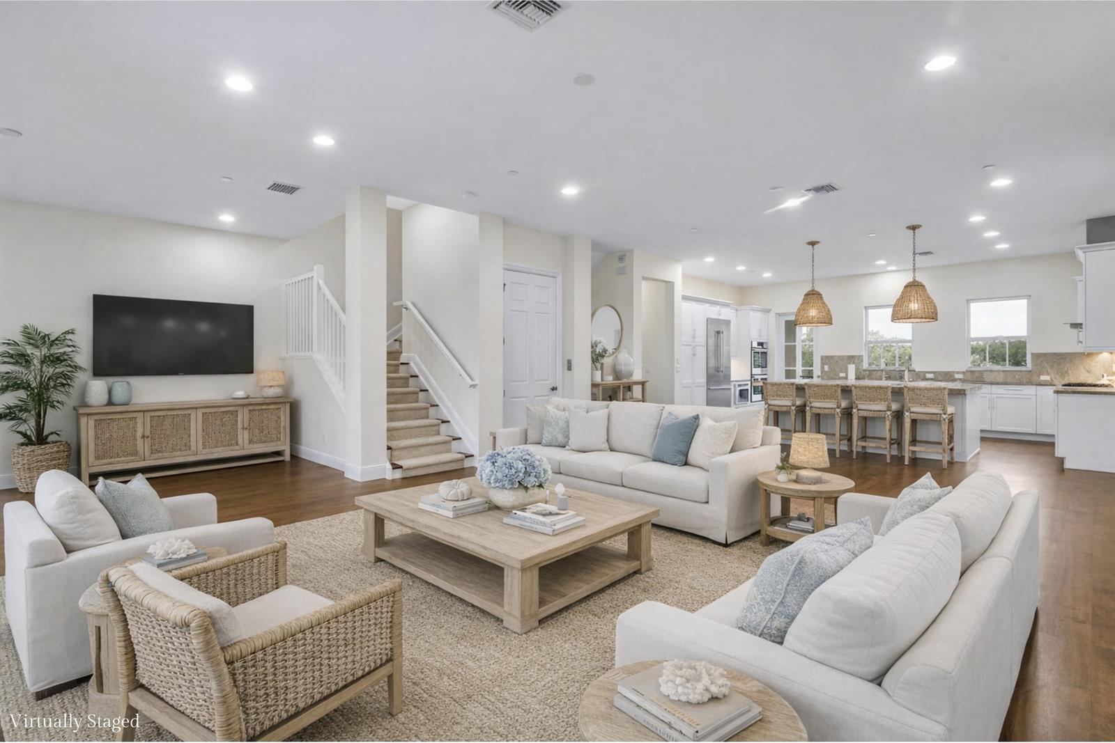 A bright, open-concept living room and kitchen featuring light wood floors and coastal-style furniture — 144 Tierra Lane # 11, Jupiter FL 33477, JUPITER, FL
