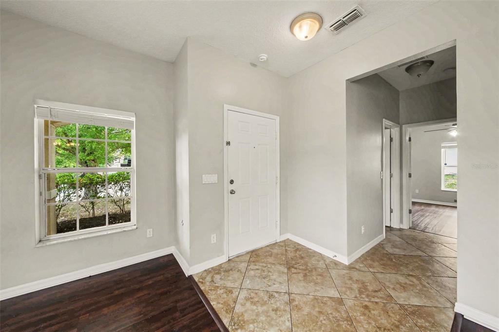An entryway features tile flooring, a white front door, a window, and an arched doorway — 30030 MESSARA COVE, MOUNT DORA, FL