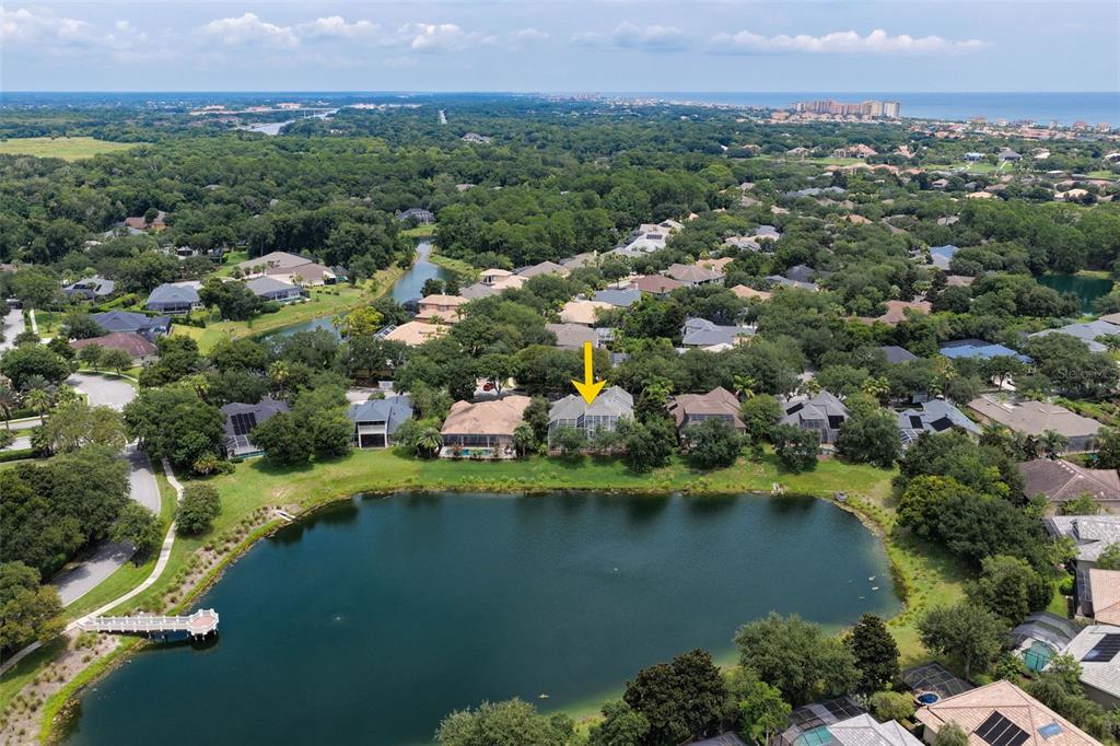 An aerial view shows a house with a screened pool deck overlooking a lake — 10 N VILLAGE PARKWAY, PALM COAST, FL