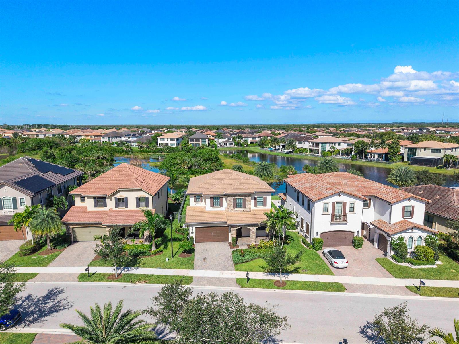 An aerial view shows three suburban houses with tile roofs and driveways facing a street — 11425 Watercrest Circle E, Parkland FL 33076, PARKLAND, FL