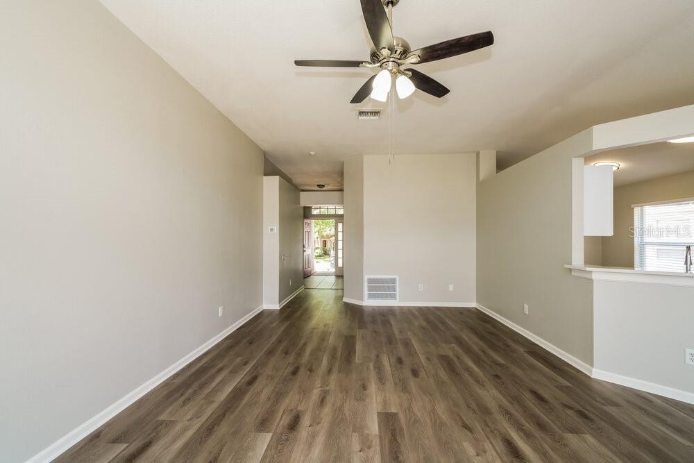 An empty room with light gray walls, wood-look flooring, and a ceiling fan — 12534 HERONS PATH PLACE, RIVERVIEW, FL